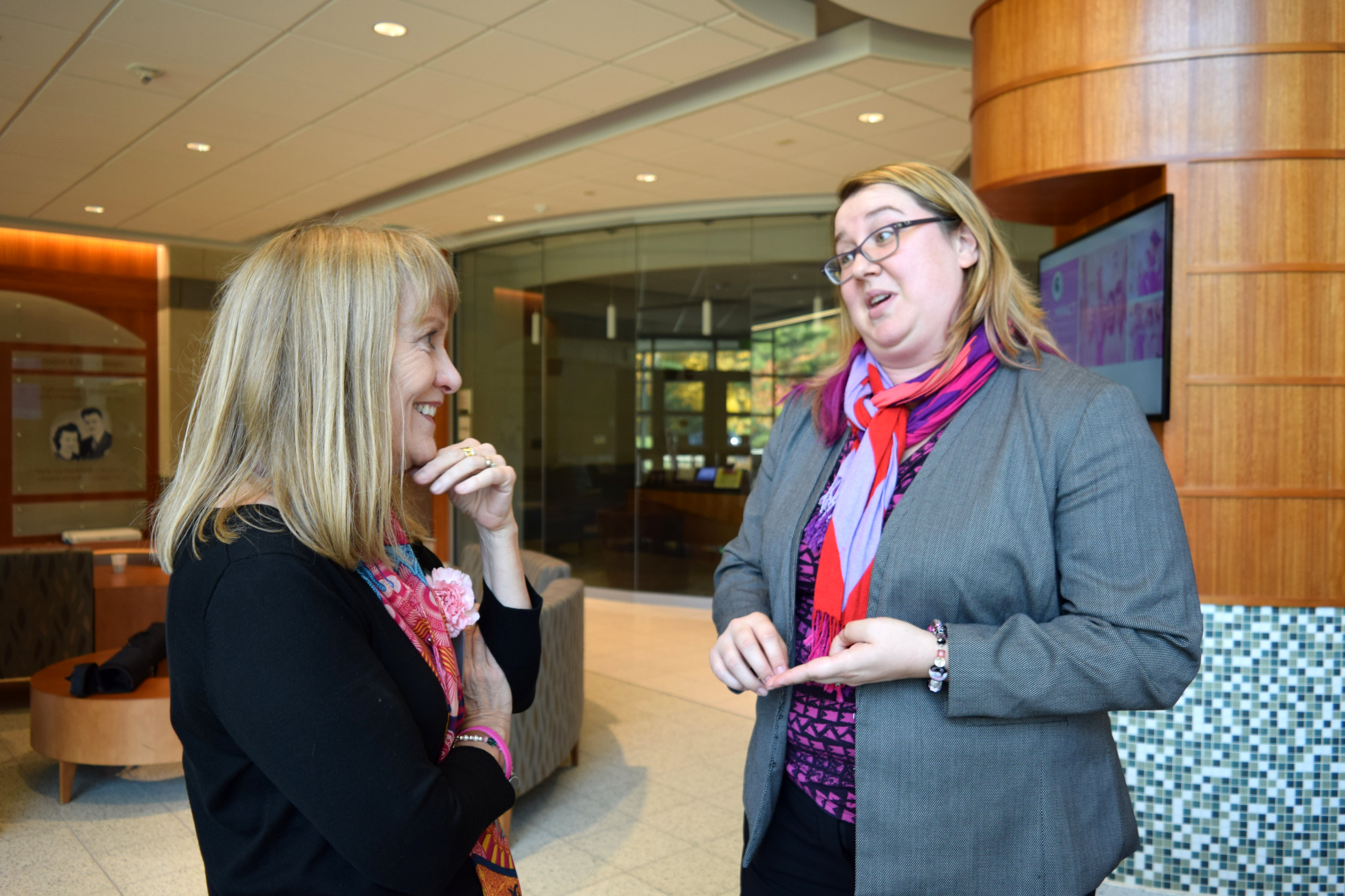 2 people talking in a lobby at an academic conference
